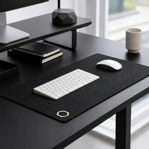 Black Difavo Desk Mat on a black desk under a white keyboard and mouse, in a calm home office