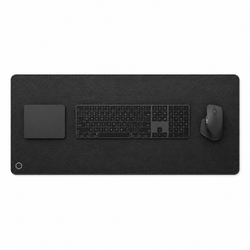 Top view of the black Difavo desk mat with keyboard, mouse and trackpad, showing the corner monogram logo